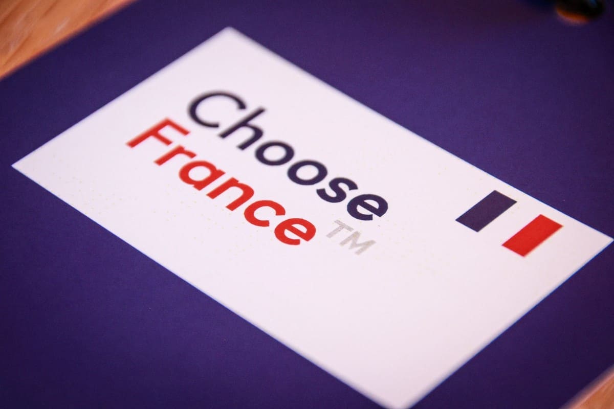 Front view of the Palace of Versailles decorated for the Choose France 2025 summit, highlighting the event celebrating investment by French companies